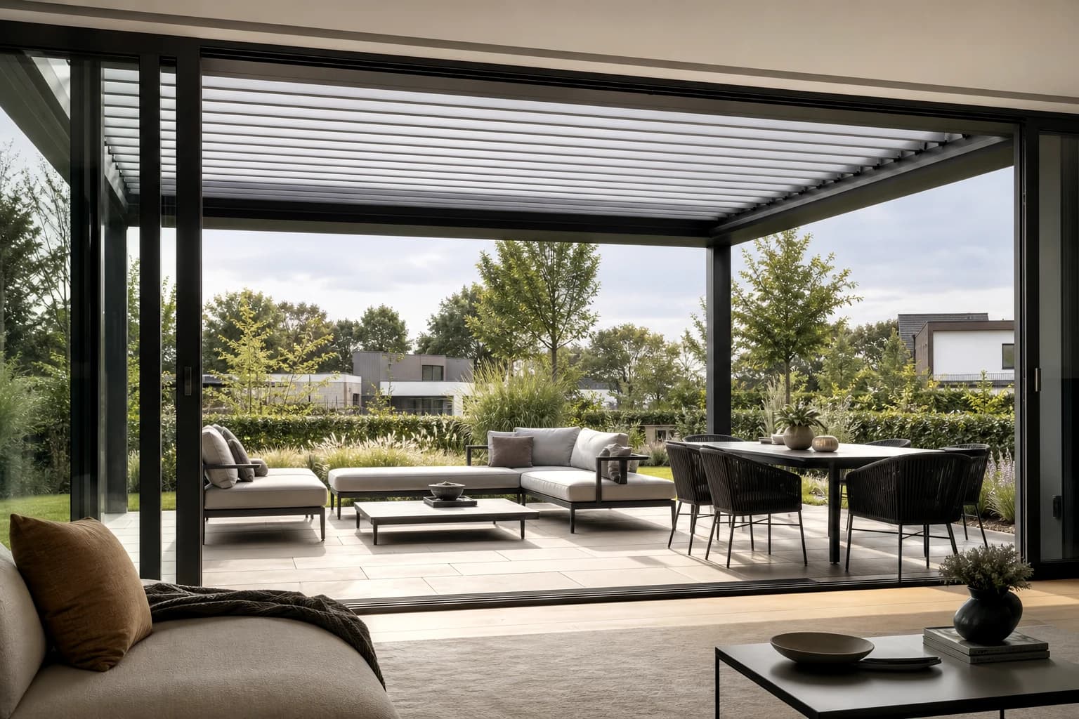 KI-Illustration: Blick aus dem Wohnraum auf eine Terrasse mit Lamellendach